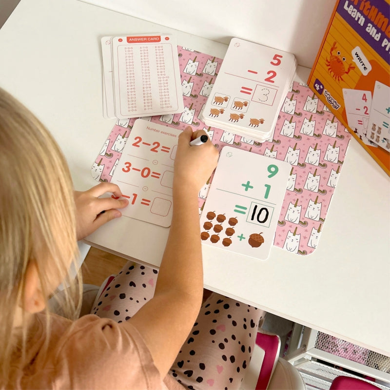 Dziecko rozwiązuje zadania matematyczne na kartach WOOPIE